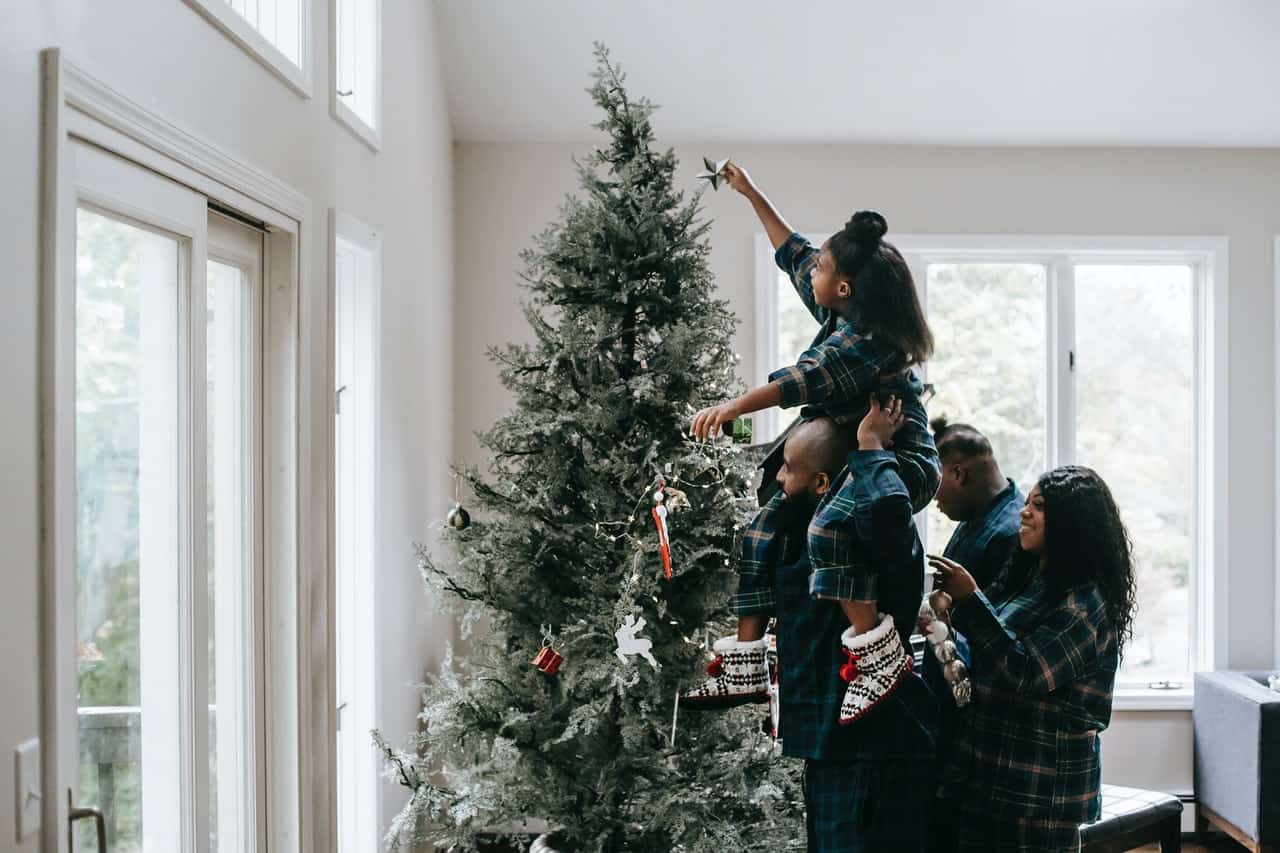 Familie hjælper hinanden med at hænge julestjerne op
